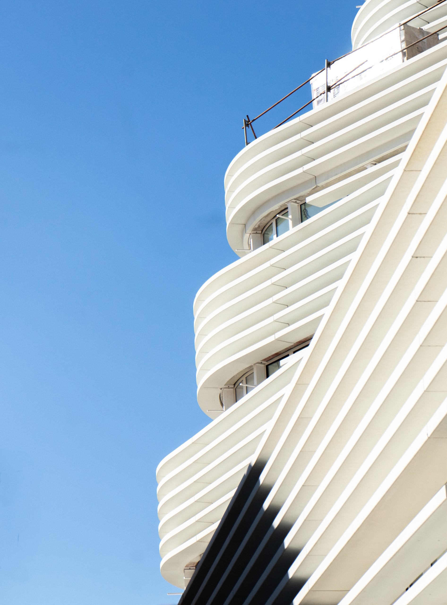 Façade de l’IFPVPS à Toulon : éléments blancs en BFUP superposés dessinant des lignes courbes autour des fenêtres