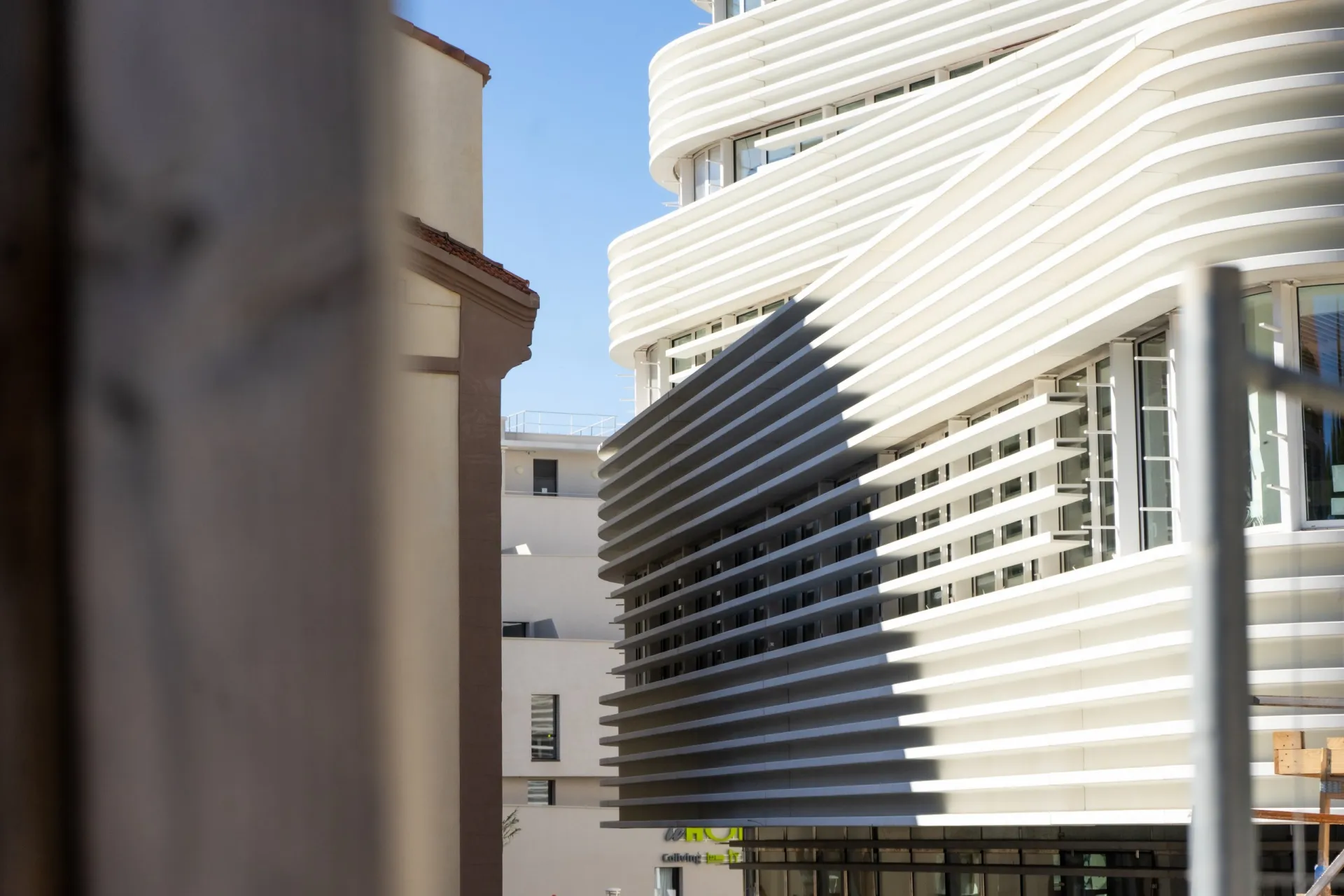 Fassade des IFPVPS in Toulon, Eckansicht: weiße, gewellte horizontale Lamellen vor den Fensterflächen