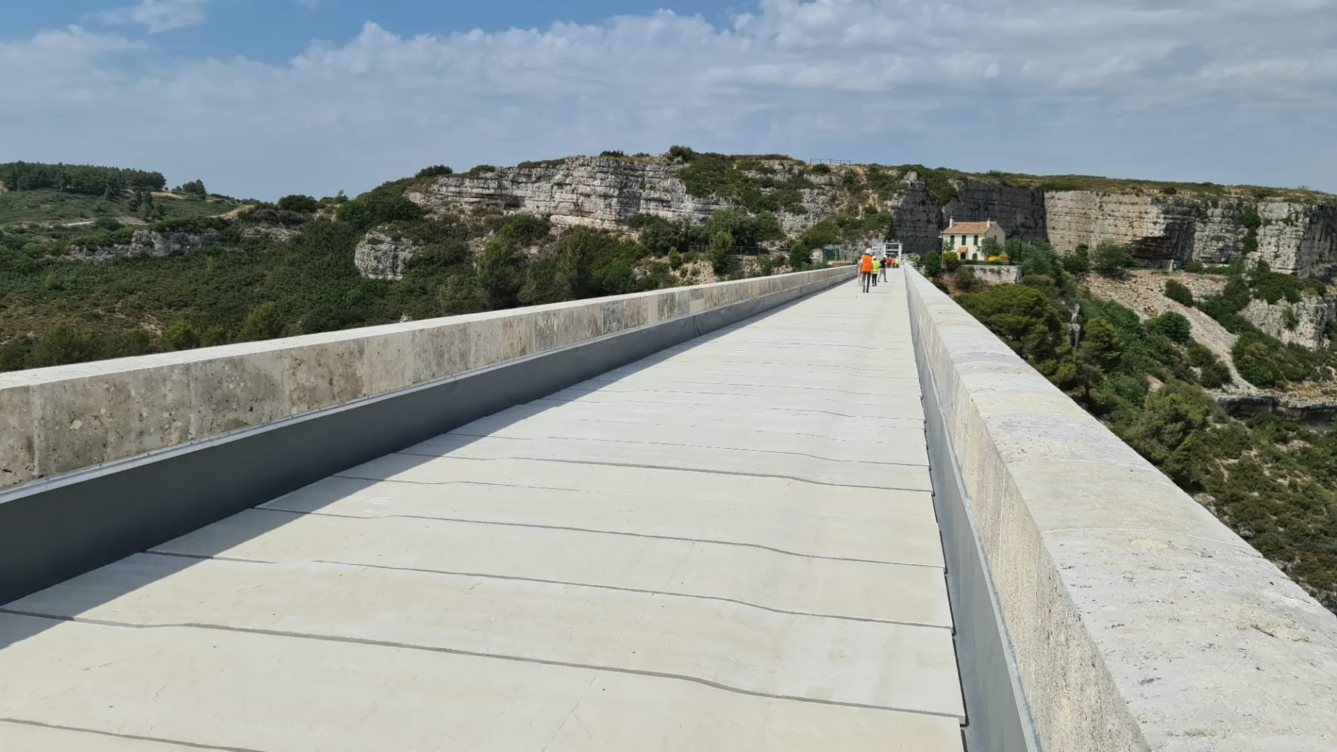 UHPC slabs laid between the stone parapets on top of the Roquefavour aqueduct, scrubland and cliffs behind